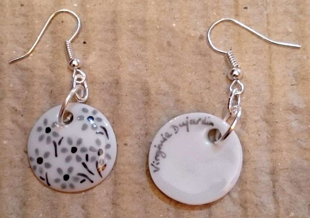 Boucles d'oreilles rondes en porcelaine personnalisées par des petites fleurs en noir et gris.